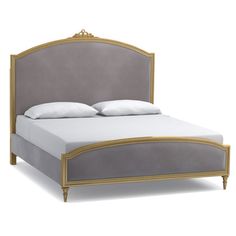 a bed that is made up and has white sheets on top of the headboard