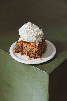 a piece of cake sitting on top of a white plate next to a green tablecloth