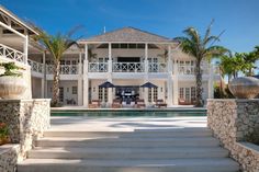 a large white house sitting next to a swimming pool