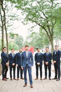 a group of men in suits and ties standing next to each other on a sidewalk