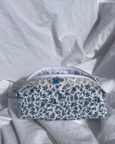 This durable white pouch with blue floral has a handle on the left-hand side, lace trimming, and a blue rosette. This pouch is perfect for holding pencils, pens, makeup, and everyday essentials. Message me with any questions you may have. I'm happy to answer! White Cosmetic Bag With Pen Holders For Everyday Use, Handmade White Pouch Cosmetic Bag, Blue Pouch Bag, Blue Pencil Case With Removable Pouch For Daily Use, Blue Pencil Case With Removable Pouch, White Pencil Case With Removable Pouch, Floral Pouch, Everyday Bag Essentials, Cute Pouch