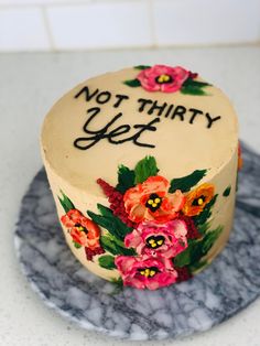 there is a cake that has been decorated with flowers and words on it, but not thirty yet