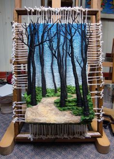 a weaving machine with trees on it in the process of being made to look like an image