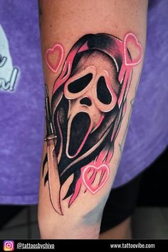 a woman's arm with a tattoo on it and a knife in the shape of a heart