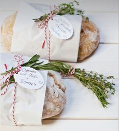 two breads wrapped in paper and tied with twine on top of each other