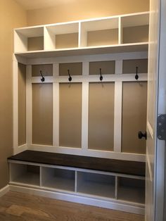 an empty room with some white shelves and benches on the wall next to each other