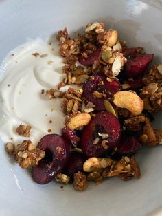 a bowl filled with yogurt, granola, and beets on top of a table