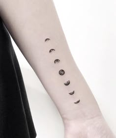 a woman's arm with phases of the moon on it