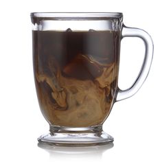 a glass cup filled with liquid on top of a white table