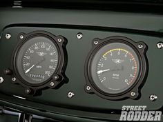 two gauges on the front of a green car