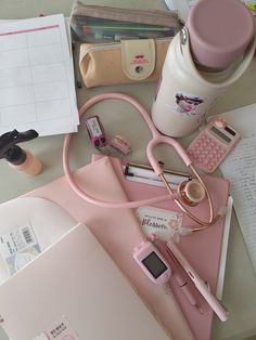 a pink desk topped with lots of office supplies