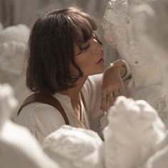 a woman is looking at some white sculptures