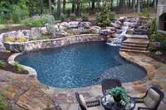 a backyard with a pool, waterfall and patio furniture