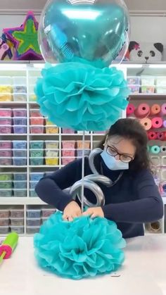 a woman wearing a face mask is making balloons