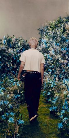 a person walking down a path with blue flowers