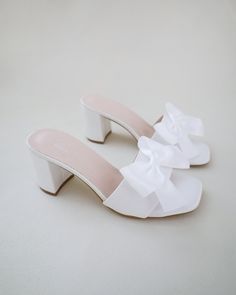 "Classic satin slip on block heel sandals for casual and dressy look. Style with satin bow at the front that adds a romantic touch, or without the bow for a classy simple style. Comfortable and easy wear for bridal wear, bridesmaids, holiday party, wedding parties, and any special occasions.  DETAILS: HEEL HEIGHT: 2.5 Inches COLORS AVAILABLE: Ivory and White UPPER: Synthetic upper and lining MATERIALS: Manmade outsole STYLE NAME: VERONA Not sure of which size to purchase? Shoes measurements are Bridesmaids Sandals, Block Heels Wedding, Bridesmaid Sandals, Sandals Wedding, Short Heels, Bridal Sandals, Cute Heels, Wedding Sandals, Block Heel Sandals