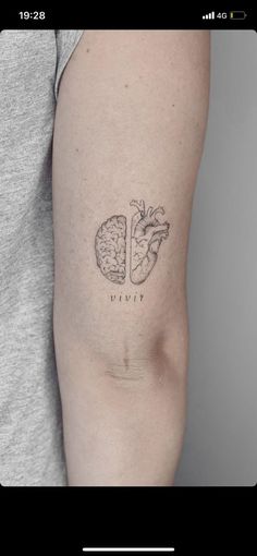 a person with a tattoo on their arm that has a heart and a piece of fruit in it