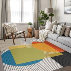 a living room filled with furniture and a large rug on top of a wooden floor