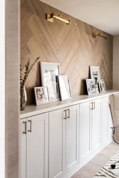 a room with white cabinets and pictures on the wall