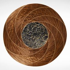 an abstract wooden sculpture with black and gold marble in the center, on a white background