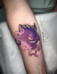 a person with a tattoo on their arm has a purple and yellow cat design on it