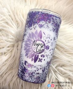 a purple and white glitter tumbler sitting on top of a furry surface with the words nurse life written on it