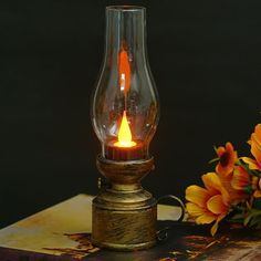 a light that is sitting on top of a book next to flowers and a vase