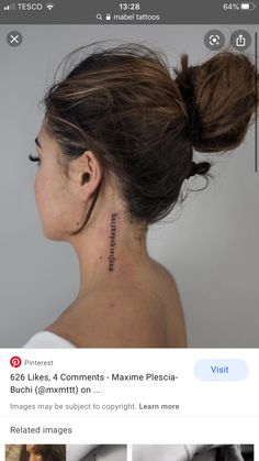 the back of a woman's neck with tattoos on it