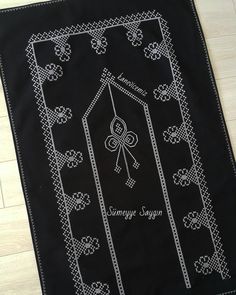 an embroidered black and white table cloth with the name sammag sagan on it