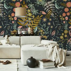 a dog sitting on a couch in front of a wallpapered with flowers and leaves