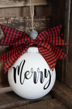 a christmas ornament with a red and black bow hanging from it's side