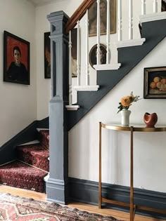 a room with stairs and paintings on the wall