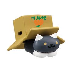 a black and white cat with a yellow hat on it's head sitting in front of a toy truck