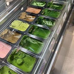 an ice cream display in a store filled with green and pink gelato