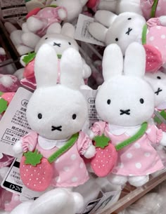 two white stuffed rabbits in pink and white polka dot dresses with green leaves on them