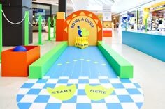 an indoor play area in a shopping mall with toys on the floor and colorful walls