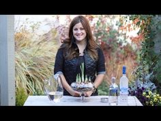 a woman sitting at a table holding a potted plant