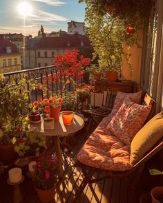 a balcony with potted plants and flowers on the table, next to a chair