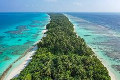 an aerial view of a tropical island in the middle of the ocean with palm trees