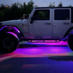 a white jeep with purple lights on it's side