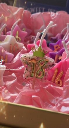 a box filled with pink and gold birthday candles