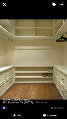 an empty closet with wooden floors and white cabinets in the center, is shown here