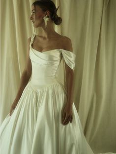 a woman in a white wedding dress posing for the camera