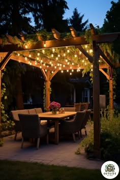 an outdoor dining area is lit up with string lights and greenery on the pergolan