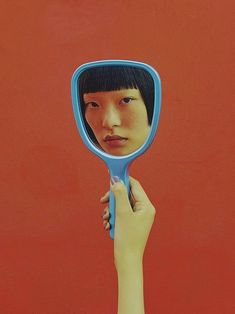 a person holding up a mirror to their face