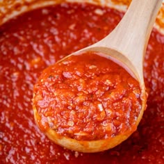 a wooden spoon filled with marinara sauce