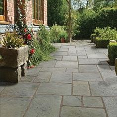 an outdoor walkway with potted plants and flowers