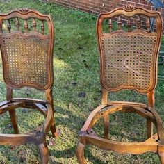 two old wooden chairs sitting in the grass