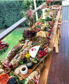 a long table filled with lots of different types of food on top of wooden boards