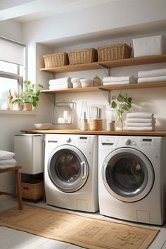 a washer and dryer sitting in a room next to some shelves with towels